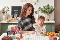 Mom and little daughter in the kitchen decorated for the new year and christmas