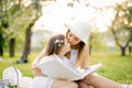 Mom and little daughter are looking at a family album with photos Royalty Free Stock Photo