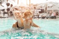 Mom and little daughter are played in the open swimming pool. Family with one child on vacation in warm countries. Positive people Royalty Free Stock Photo