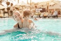 Mom and little daughter are played in the open swimming pool. Family with one child on vacation in warm countries Royalty Free Stock Photo