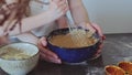 Mom and little daughter are preparing dough together in a bowl in the kitchen. Happy family preparing pie cake Royalty Free Stock Photo