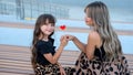 Mom and little daughter with red heart shaped lollipop outdoor Royalty Free Stock Photo