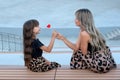 Mom and little daughter with red heart shaped lollipop outdoor Royalty Free Stock Photo