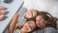 Mom, little daughter and son take a selfie while lying on the floor. Royalty Free Stock Photo