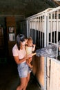 Mom with a little girl with a carrot in her hand feed a horse on a farm Royalty Free Stock Photo