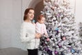Mom with a little girl decorate a Christmas tree. Waiting for the holiday. Preparing for the Christmas holidays Royalty Free Stock Photo