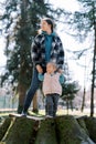 Mom with a little girl stand on a huge stump in a sunny meadow and look away Royalty Free Stock Photo