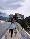 Budva, Montenegro - 11 august 2023: Mom and little girl walk along the sidewalk along the highway to high-rise buildings