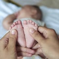 Mom massaging newborn`s feet