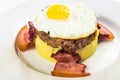 fried egg and meat patty on top of smashed potato, decorated with bacon Royalty Free Stock Photo