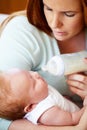 Mom, milk and feed baby from bottle for nutrition, healthy breakfast and diet in the morning. Mother, child and feeding Royalty Free Stock Photo