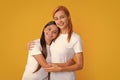 Mom mum and kid daughter in t-shirt embrace cudding isolated on yellow color background studio. Mothers day love family. Royalty Free Stock Photo