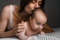 Mom, mummy, young mother with little baby daughter. Breast-feeding. Mum kissing,hugging child. Newborn cute happy girl Royalty Free Stock Photo