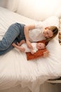 mom with a newborn baby lies on the bed. mother kisses the child. mother's love Royalty Free Stock Photo