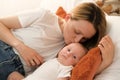 mom with a newborn baby lies on the bed. mother kisses the child. mother's love Royalty Free Stock Photo