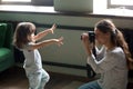 Mom photographer making photo of kid daughter on digital camera Royalty Free Stock Photo