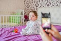 Mom photographs her baby on the phone. Mother takes a photo of her newborn baby on a smartphone. Family memories Royalty Free Stock Photo