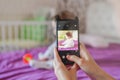 Mom photographs her baby on the phone. Mother takes a photo of her newborn baby on a smartphone. Family memories