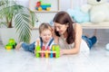 Mom plays with the child at home in the educational toys in the children`s room. A happy, loving family Royalty Free Stock Photo