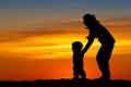 Mom plays with the child on the snow at sunset Royalty Free Stock Photo