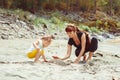 Mom plays with her daughter in the sand Royalty Free Stock Photo