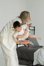 Mom plays with her little daughter, holds her in her arms - they fly Royalty Free Stock Photo