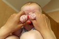 Mom plays with her newborn son lying on her lap. Young family having fun at home. Royalty Free Stock Photo