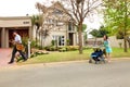 Mom with pram and Mailman delivering mail in a wealthy suburban neighborhood street Royalty Free Stock Photo