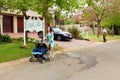 Mom with pram and Mailman delivering mail in a wealthy suburban neighborhood street Royalty Free Stock Photo