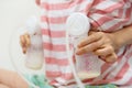 Mom pumping milk to bottles by machine