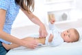 Mom puts on diaper baby changing table Royalty Free Stock Photo