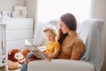 Mom reading book with baby boy toddler at home. Early age children education, development. Mother and child kid spending time Royalty Free Stock Photo