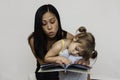 Mom reading book to 3-year-old daughter