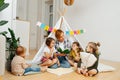 Mom reading bedtime story for children in a hut at home