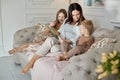 Mom reads a book to the children. A woman tells a story to a boy and a girl before going to bed. Mom daughter and son relax