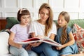 Mom reads a book to small children in a cozy home Royalty Free Stock Photo