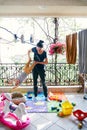 Mom rocks little child upside down standing on the balcony