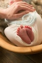 Mom`s hands are holding little cute legs of a newborn baby. Happy motherhood Royalty Free Stock Photo