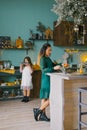 Mom`s idle serving of the table for dinner, her daughter helps her in the kitchen Royalty Free Stock Photo