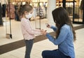 Mother sanitizing her daughter`s hands with antibacterial hand spray