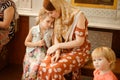 Mom with daughter sit on bench in Church Orthodox