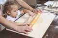 Mom shows her daughters how to roll out dough for making dumplings Royalty Free Stock Photo