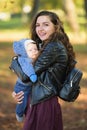 Mom and sleeping baby. Closeup portrait of a cheerful smiling mother with a newborn baby girl sleeping on her shoulder, happy Royalty Free Stock Photo