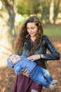 Mom and sleeping baby. Closeup portrait of a cheerful smiling mother with a newborn baby girl sleeping on her shoulder, happy Royalty Free Stock Photo