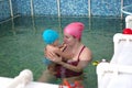 Mom with a small baby in a special children`s pool in the medical center