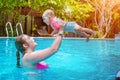 Mom with a small child of eight months having fun and swimming in the pool. Summer vacation at sea. Woman holding a child over her Royalty Free Stock Photo