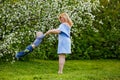 Mom and son in a blooming apple orchard in spring. A woman holds a child in her arms, plays and has fun with it