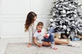Mom with son at christmas tree with gifts garland winter Royalty Free Stock Photo