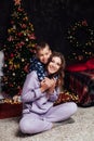 Mom with son at christmas tree with gifts garland winter Royalty Free Stock Photo