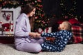 Mom with son at christmas tree with gifts garland winter Royalty Free Stock Photo